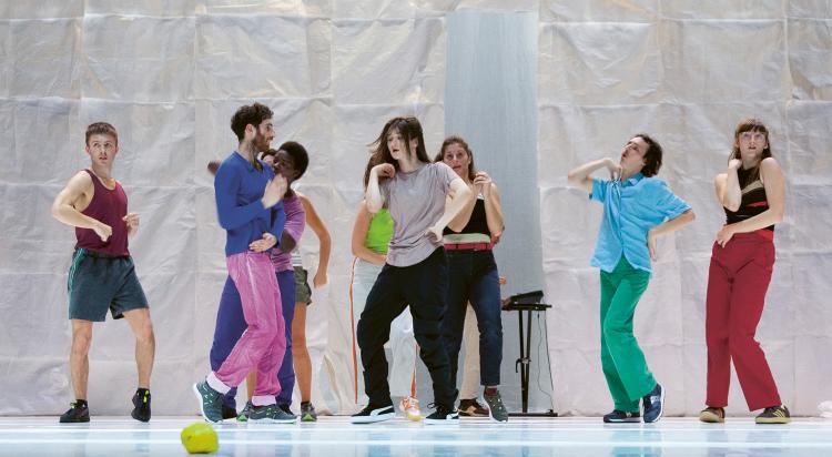 Photo de 9 danseurs et danseuses sur scène habillés de vêtements très colorés