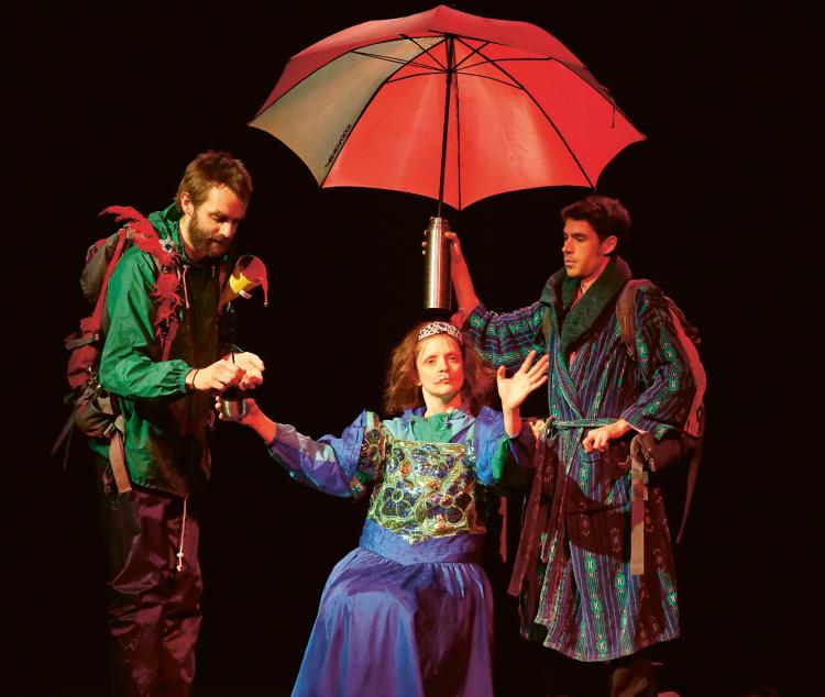 Photo de deux hommes en train de tenir un parapluie au dessus d'une femme déguisée en princesse